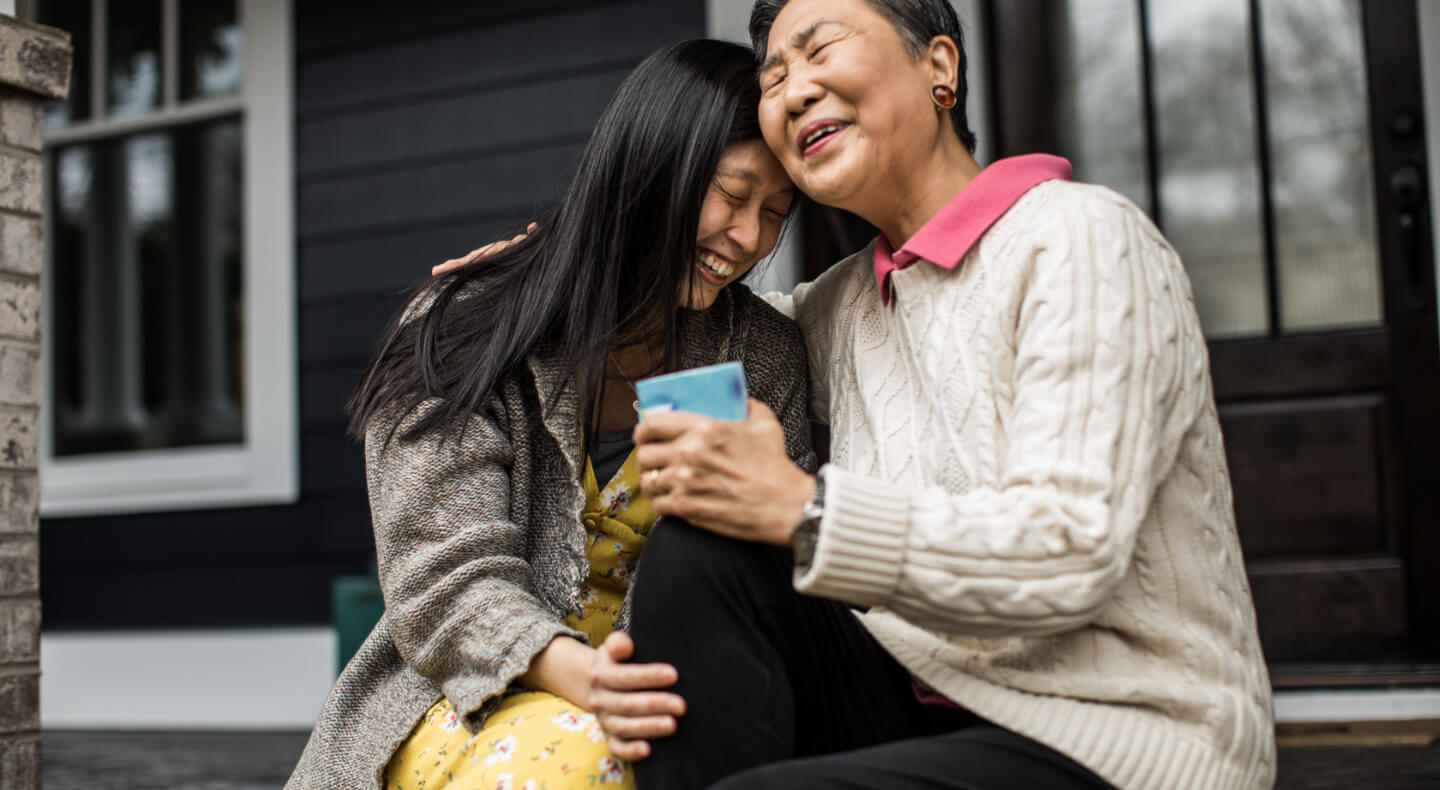 mom and daughter laughing on porch